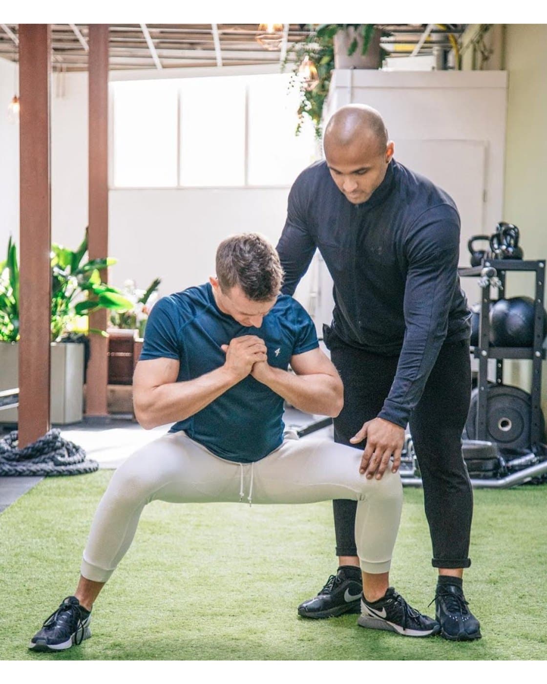 Claudio coaching a client through a movement in the gym