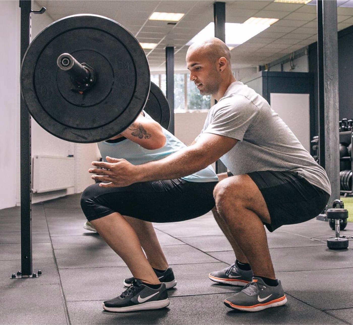 Claudio coaching a barbell squat